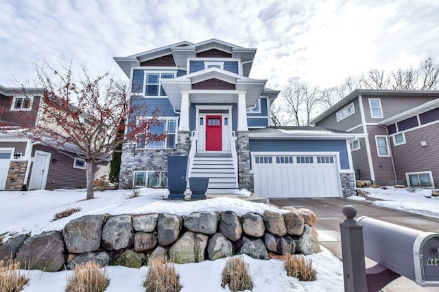 craftsman-style home featuring a garage, stone siding, and driveway