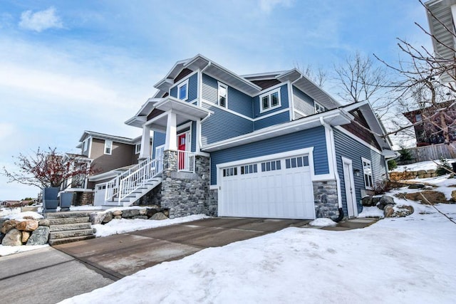 craftsman-style house with a garage, stone siding, and concrete driveway