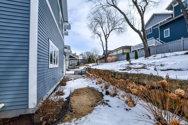 snowy yard featuring fence and a residential view