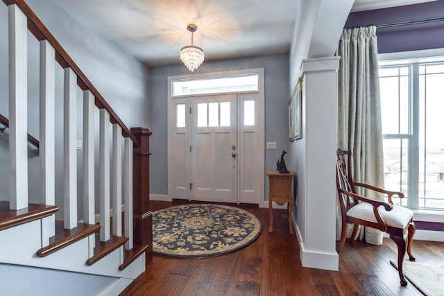 foyer entrance with a notable chandelier, stairs, baseboards, and hardwood / wood-style floors