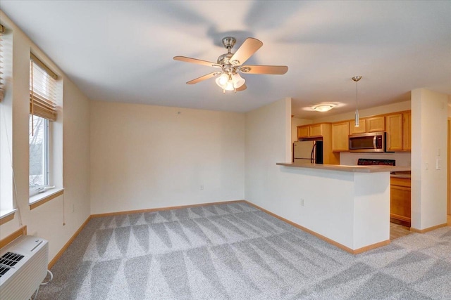 kitchen with baseboards, light colored carpet, stainless steel microwave, fridge, and a wall mounted AC