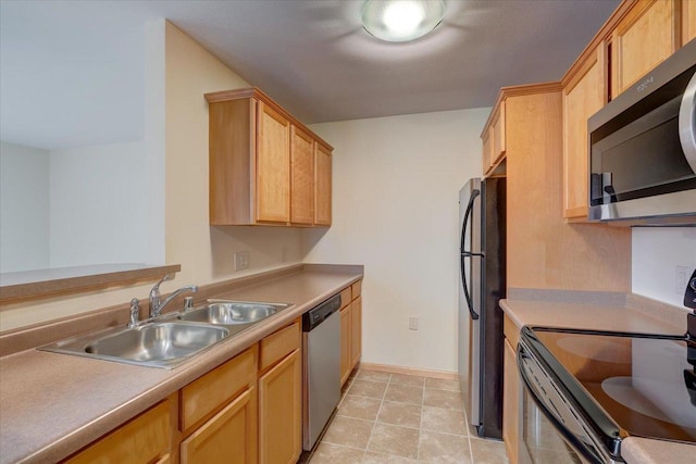 kitchen with light countertops, appliances with stainless steel finishes, a sink, and baseboards