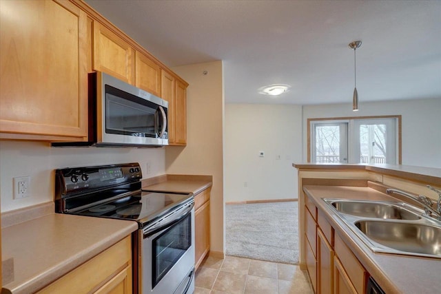 kitchen featuring stainless steel appliances, light countertops, hanging light fixtures, a sink, and baseboards