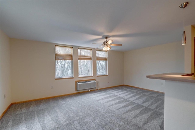 spare room with baseboards, light colored carpet, a ceiling fan, and a wall mounted AC