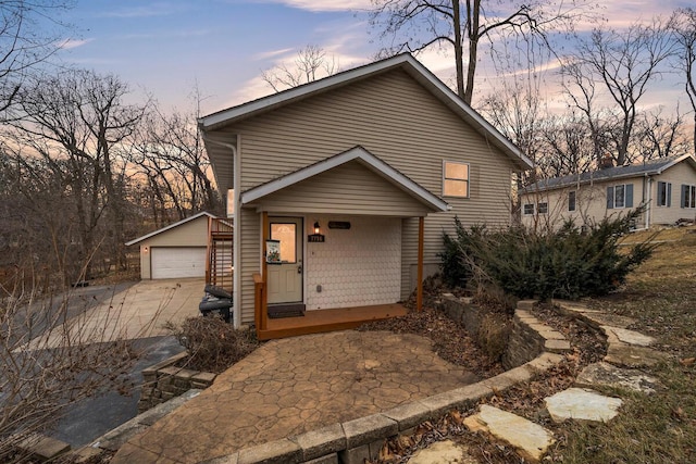 view of front of property with covered porch, an outdoor structure, and a detached garage