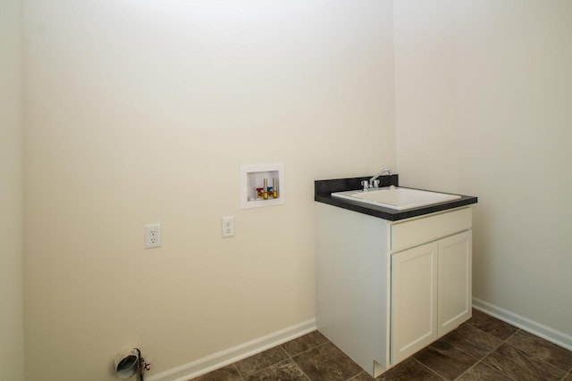 laundry room featuring washer hookup, a sink, cabinet space, and baseboards