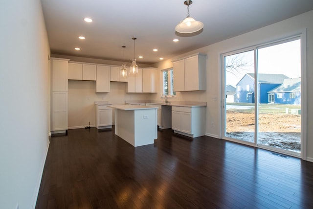 kitchen featuring white cabinets, dark wood-style flooring, a wealth of natural light, and a center island