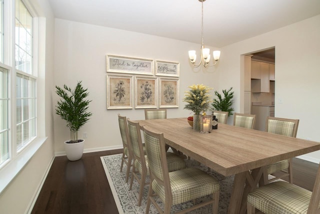 dining space with dark wood-style floors, a notable chandelier, and baseboards