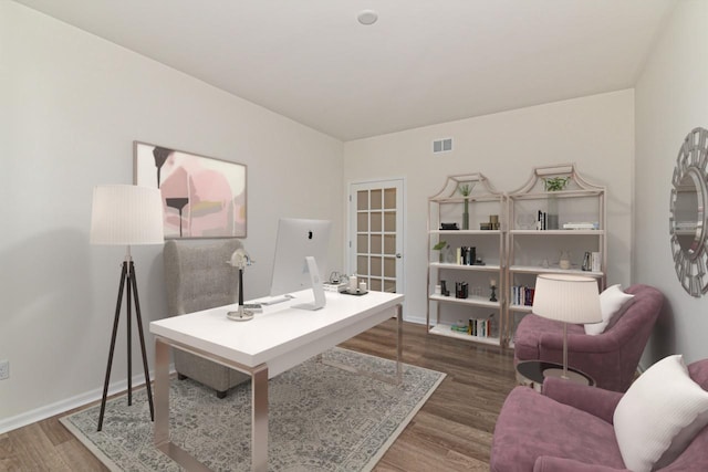 office area featuring wood finished floors, visible vents, and baseboards