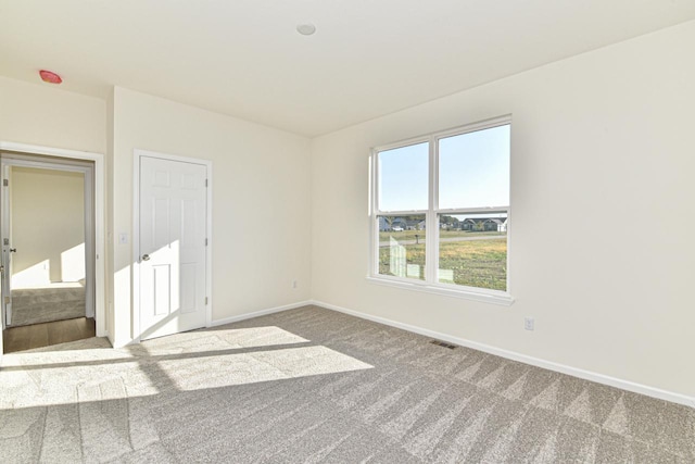 unfurnished bedroom with carpet, visible vents, and baseboards