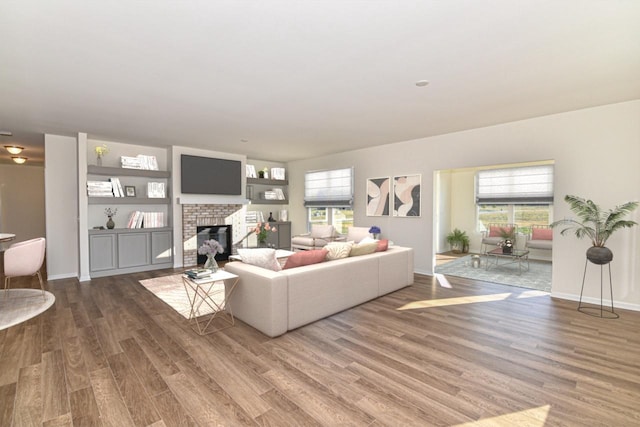 living area with a brick fireplace, wood finished floors, and a wealth of natural light