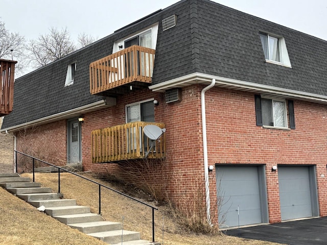 view of side of home featuring a shingled roof and mansard roof