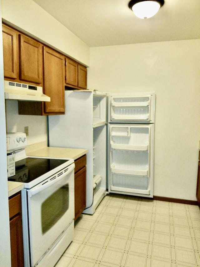 kitchen with light countertops, white electric range, under cabinet range hood, and light floors