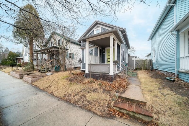 shotgun-style home with fence and a porch