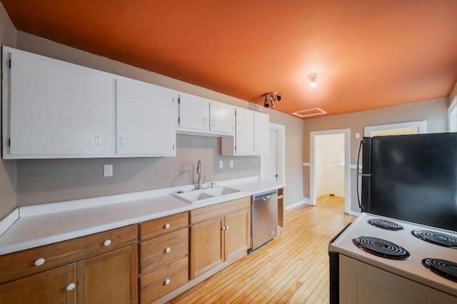 kitchen featuring light countertops, white electric range, stainless steel dishwasher, freestanding refrigerator, and a sink