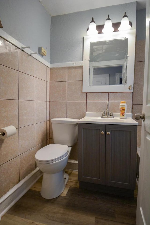 bathroom with vanity, tile walls, toilet, and wood finished floors