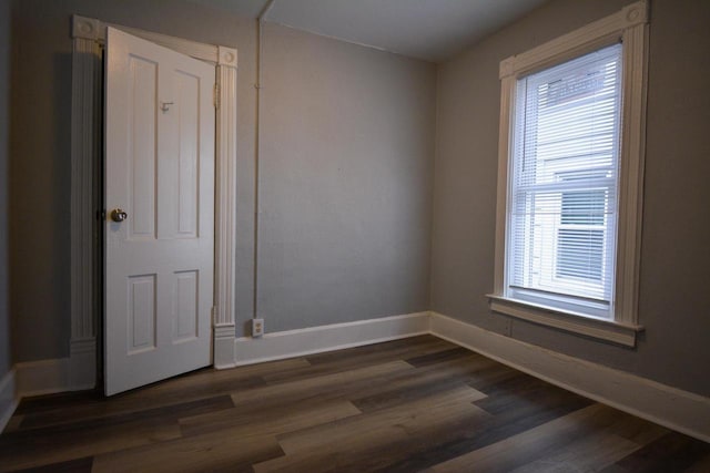 empty room featuring dark wood-style floors and baseboards