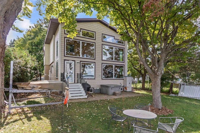 rear view of house with fence and a lawn