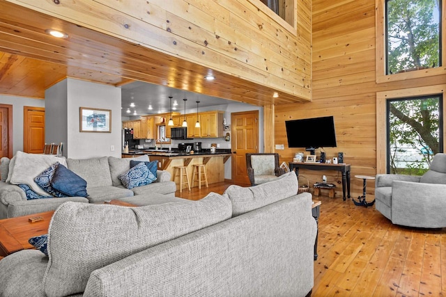 W3084 Blackbird Point Dr, Green Lake, WI 53946 - living area with light wood finished floors, wood walls, a high ceiling, and recessed lighting