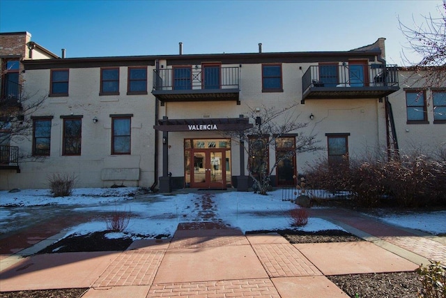 exterior space with brick siding, french doors, and a balcony