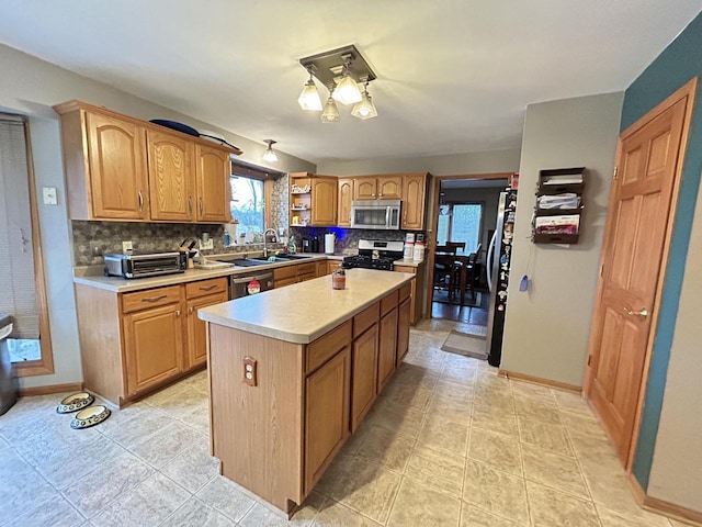 kitchen with decorative backsplash, stainless steel appliances, light countertops, and a center island