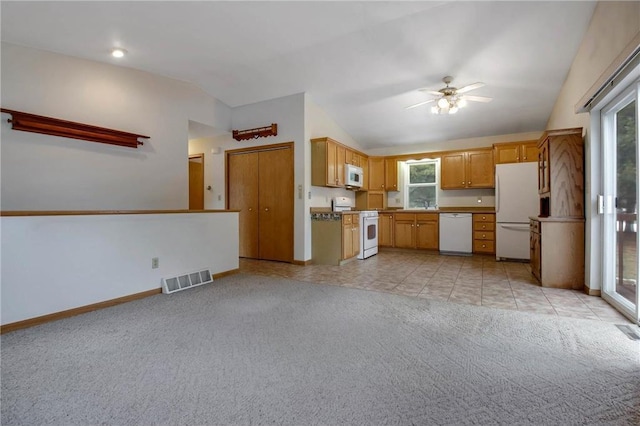 kitchen with white appliances, visible vents, vaulted ceiling, and light colored carpet