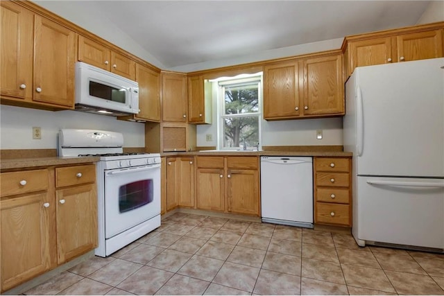 kitchen featuring white appliances, light tile patterned floors, vaulted ceiling, and brown cabinetry