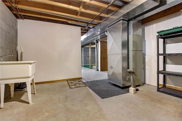 unfinished basement featuring baseboards, stairs, and heating unit