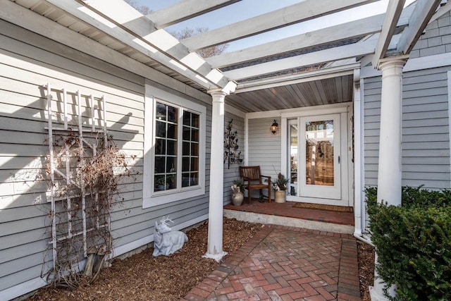 doorway to property with a porch and a pergola