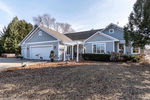 view of front of property with a garage, driveway, and a pergola