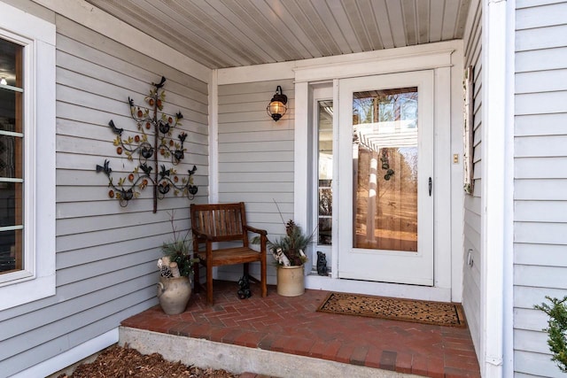 view of exterior entry featuring covered porch