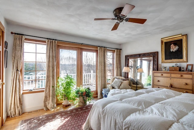 bedroom featuring visible vents, a ceiling fan, light wood-type flooring, and baseboards