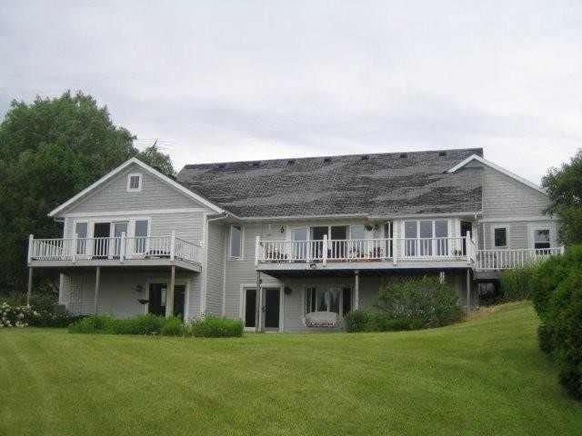 rear view of house with a deck and a yard