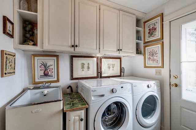 laundry area featuring washing machine and clothes dryer and cabinet space