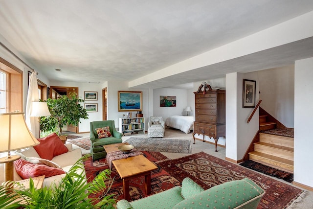 carpeted living room featuring stairway and baseboards