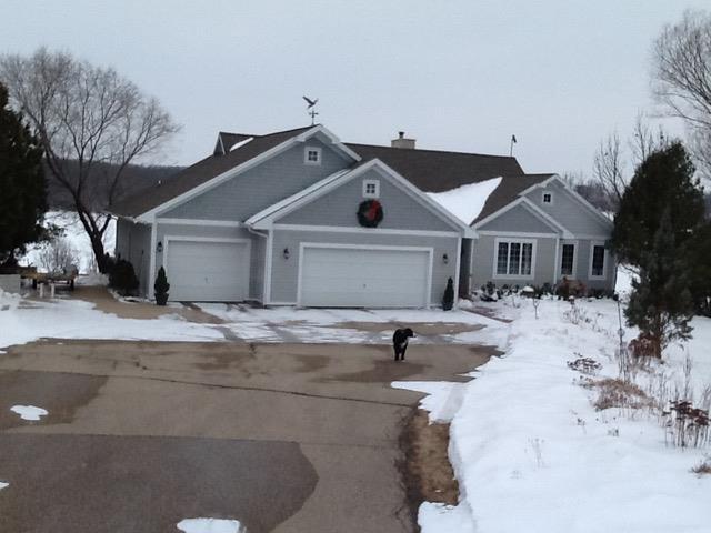 view of front of home featuring concrete driveway, a garage, and a chimney