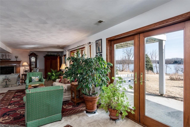 interior space featuring a fireplace, visible vents, and a water view