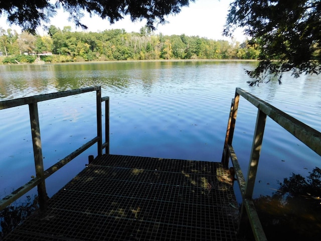 view of dock with a forest view and a water view