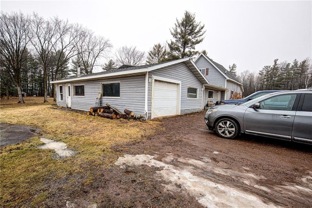 view of home's exterior featuring a garage and dirt driveway