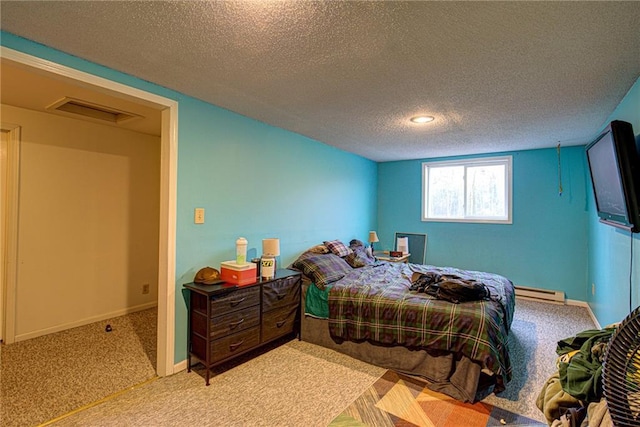 bedroom featuring a baseboard heating unit, a textured ceiling, visible vents, and baseboards