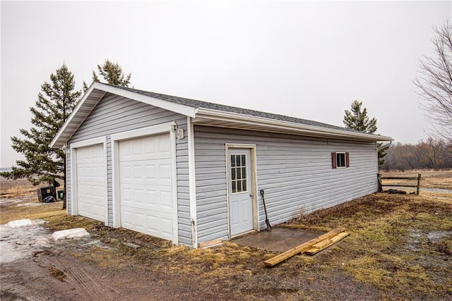 detached garage featuring fence