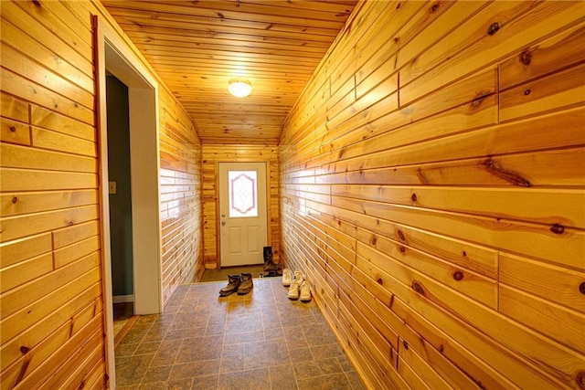 doorway to outside with wood walls and wood ceiling