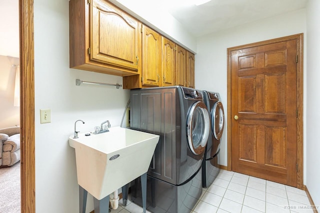 washroom with washer and dryer, cabinet space, a sink, and light tile patterned floors