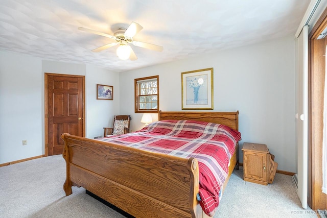 bedroom with light colored carpet, ceiling fan, and baseboards