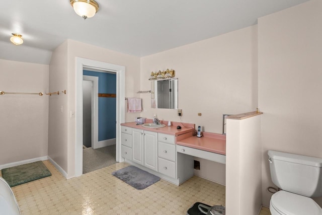 bathroom with vanity, toilet, and baseboards