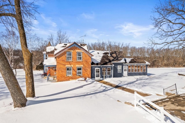 view of front facade featuring brick siding and a sunroom