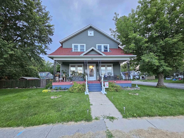 view of front of house with fence, a front lawn, and a porch