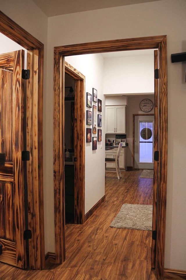 hall featuring dark wood finished floors and baseboards