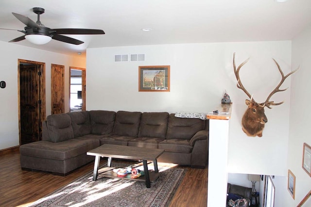 living room with dark wood-style floors, visible vents, and a ceiling fan