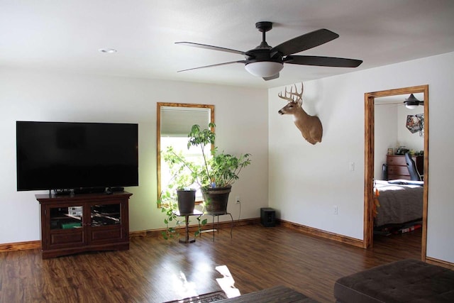 unfurnished living room featuring wood finished floors, a ceiling fan, and baseboards